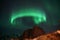 Ring green shaped northern light on dark sky in Norway