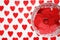 Ring on red hearts in a crystal glass on a white background with hearts