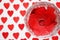 Ring on red hearts in a crystal glass on a white background with hearts