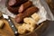 Ring Salami pork sausage with German BierbeiÃŸer and Edamer cheese in wax paper with knife on wooden board background for Brotzeit