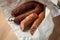 Ring Salami pork sausage with German BierbeiÃŸer in wax paper on wooden board background for Brotzeit dinner