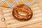 Ring shaped bread roll sprinkled with sesame on cutting board