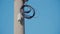 Ringed black electric cable on concrete pillar pole on blue sky.