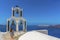 Ringing the bells of a  tower on a church on Skaros Rock in Santorini