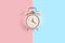 Ringing twin bell vintage classic alarm clock Isolated on blue and pink pastel colorful trendy background