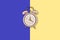 Ringing twin bell vintage classic alarm clock Isolated on phantom blue and yellow pastel colorful trendy background