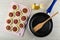 Rings of squash with forcemeat on cutting board, bottle of vegetable oil, spatula in frying pan on table. Top view