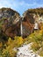 Rinka Falls in Logar valley - mountains Kamnik Alps and autumn in Slovenia under blue sky
