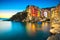 Riomaggiore town, cape and sea landscape at sunset. Cinque Terre, Liguria, Italy