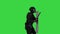 Riot policeman with a shield up and a rubber baton walking by on a Green Screen, Chroma Key.