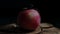 Ripe apple on a black background, camera spinning around