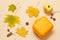 Ripe apple, lunchbox and dry leaves on a beige background, Top view