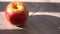 Ripe apple on a wooden background. sun shadow falls on the fruit