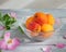 Ripe apricot fruit dessert in a glass vase and flowering rosehip twigs