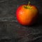 Ripe autumn apples red and yellow on a black stone background from slate. Harvesting. Vitamins are good for health.