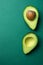 Ripe Beautiful Evenly Halved Organic Australian Avocado with Pit on Dark Green Solid Background. Healthy Lifestyle Vegan Vitamin E