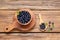 Ripe bilberries and leaves on wooden table, flat lay