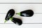 Ripe black eggplant, aubergine, guinea squash on wooden table