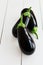 Ripe black eggplant, aubergine, guinea squash on wooden table