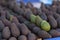 Ripe black purple and green hass avocados in basket on supermarket counter