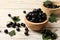 Ripe blackcurrants and leaves on light wooden table, closeup