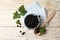 Ripe blackcurrants and leaves on light wooden table, flat lay