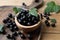 Ripe blackcurrants and leaves on wooden table, closeup