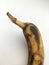 Ripe blackened banana with a long tail. Abstract wallpaper.