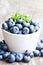 Ripe blueberries in a bowl with thyme leaves