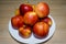 Ripe bright red Florina apples on a white ceramic plate