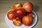 Ripe bright red Florina apples on a white ceramic plate