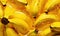 Ripe bunch bananas with glistening droplets on a vibrant yellow backdrop. Created by AI