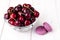 Ripe burgundy cherry in bowl on table