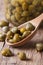 Ripe capers in a wooden spoon macro vertical