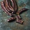 Ripe carob beans on a green surface