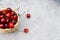 Ripe cherries in a basket on a light gray granite background. Tope view