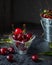 Ripe cherries in a glass vase and a tin bucket