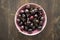 Ripe cherries in a rustic bowl on a wooden plate or table. Flat lay and top view food concept