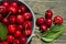 ripe cherry berries in a bowl on a dark background of wood close-up