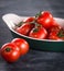 Ripe cherry tomatoes in a bowl on a black background.