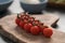 Ripe cherry tomatoes on a branch on wood board