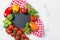 Ripe cherry tomatoes, mini bell peppers, fresh basil leaves on stone table with chalkboard, cooking ingredients, top view