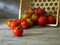 Ripe cherry tomatoes in overturned basket on wooden table