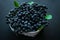 Ripe chokeberry berries in a basket on a black background Aronia melanocarpa. Useful black rowan berries.
