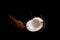 Ripe coconut is broken into two halves isolated on a black background close-up. the insides of the tropical palm fetus