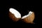 Ripe coconut is broken into two halves isolated on a black background close-up. the insides of the tropical palm fetus