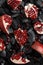 Ripe cut pomegranate. Black charcoal background