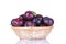 ripe delicious plums in a wicker basket on a white isolated background