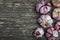 Ripe dry heads of garlic on a gray old shabby wooden background in natural daylight. Artistic creative mockup in rustic style with