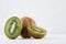 Ripe fleshy green kiwi group with juicy slices on soft light white table.